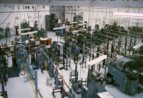 A large shop floor featuring an array of lathes and machinery in the 1980s, highlighting a dynamic shop floor atmosphere.