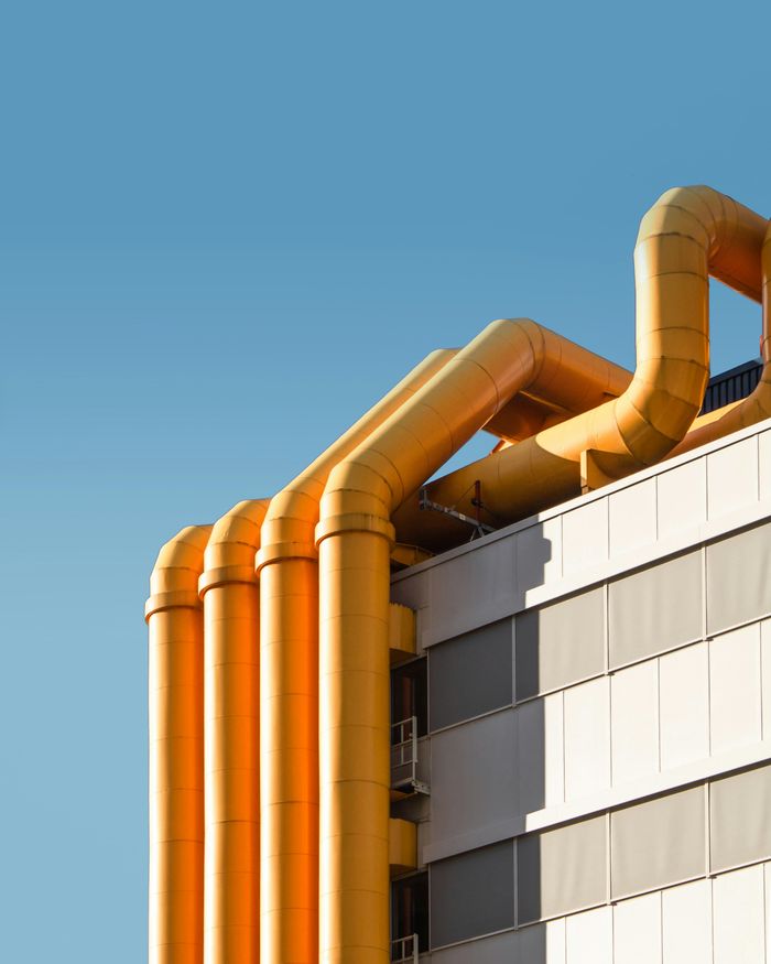 A large building featuring prominent yellow pipes along its exterior, showcasing industrial architecture and design.